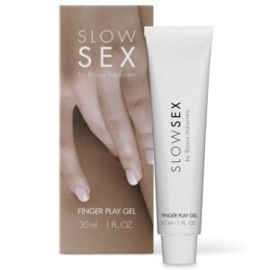 Imagem de um produto chamado 'Slow Sex Finger Play Gel' da marca Bijoux Indiscrets. O produto é um gel íntimo embalado em um tubo branco de 30 ml, com a marca 'Slow Sex' impressa verticalmente. Ao lado, está a embalagem externa que mostra uma mão com dedos delicadamente posicionados sobre um fundo neutro, destacando o tema de intimidade e sensualidade. O gel é projetado para uso pessoal e oferece uma experiência sensorial aprimorada para o toque.